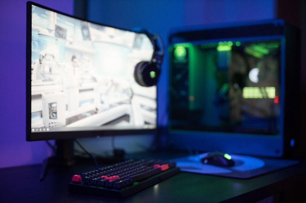 Gaming-pc med skærm og farvet lys på et skrivebord
